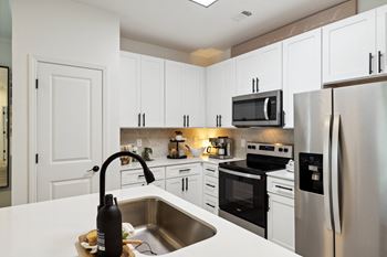a kitchen with stainless steel appliances and white cabinets